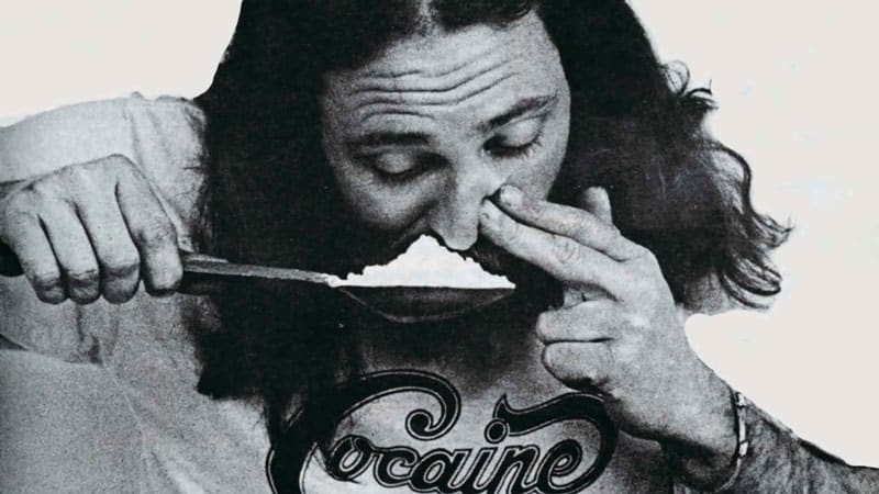 Un homme sniff une cuillère de cocaïne