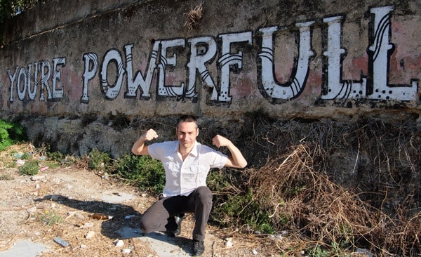 Tony derrière "You're powerfull" écrit sur un mur.